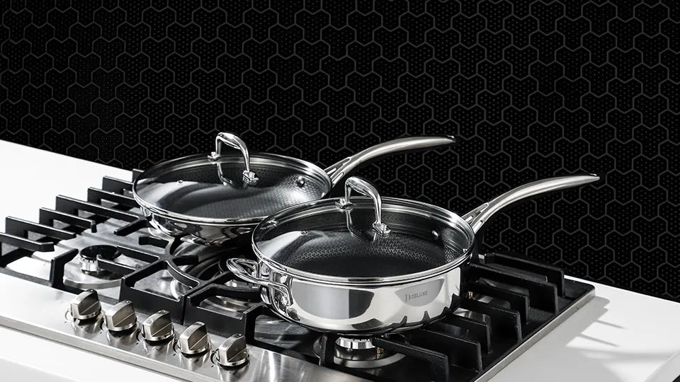 Deluxe Cookware stainless steel saucepans with glass lids on gas stovetop against black honeycomb background